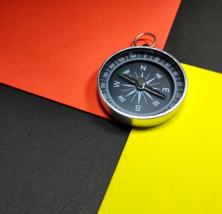 Selective focus.Compass with colorful background.Shot were noise and grain.